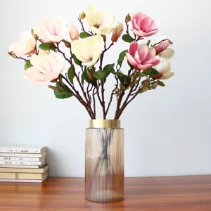 Künstlicher Magnolienblumenstrauß mit Glasvase für die Heimdekoration im Wohnzimmer Tisch.