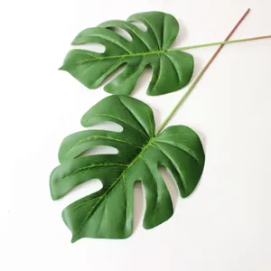 Dettaglio di foglie di monstera artificiali, pianta tropicale verde per decorazioni e composizioni.