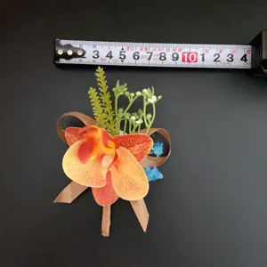 Détail de boutonnière d'orchidée artificielle avec ruban de mesure pour mariage et événements.