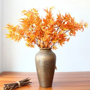 Kunstmatige esdoornblad herfst bloemstuk met decoratieve vaas voor thuisdecoratie.