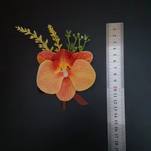 Boutonnière d'orchidée artificielle avec des pétales jaunes et rouges pour mariages et cérémonies.