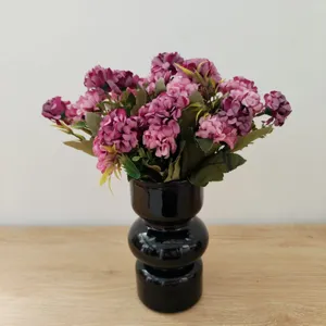 Künstlicher Blumenstrauß mit schwarzer Vase, perfekte Heimdekoration und Tischgestaltung.