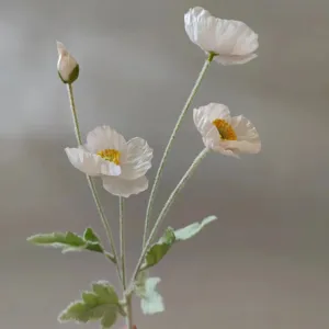 Artificial poppy flower detail shot, white silk poppy stem with buds and furry green leaves for decor.