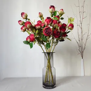Detail view of artificial red rose bouquet in glass vase, elegant home decor photography prop.