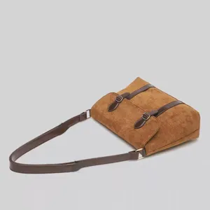 Retro brown suede shoulder bag detail view featuring classic double buckle straps and style.