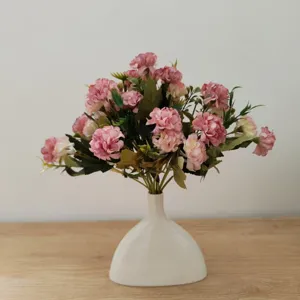 Nahaufnahme des rosa künstlichen Blumenstraußes in einer weißen Vase, ideal für die Heimdekoration.