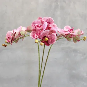 Detailed close-up of artificial Phalaenopsis orchid, realistic pink speckled silk flowers for home decor.