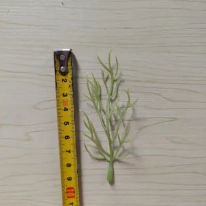 Close-up of green PVC artificial leaf with tape measure for DIY floral arrangement details.