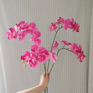Artificial pink Phalaenopsis orchid flower stem, detail view of silk floral decor.