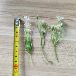 Detail view of artificial white flower stems with green leaves for DIY crafts and floral design.