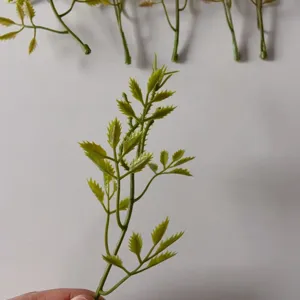 Green artificial leaf branches close-up detail for DIY crafts and floral accessories.