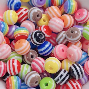 Gros plan de perles rondes en resine rayee coloree pour la creation de bijoux DIY et loisirs.