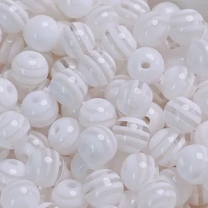 Gros plan détaillé de perles en résine rayées blanches, parfaites pour les bijoux et bracelets.