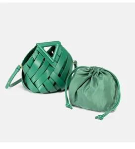 Green woven leather handbag with distinctive triangle handle and matching inner pouch detail.
