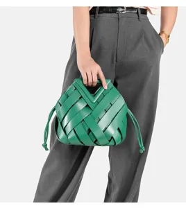 Green woven leather handbag detail featuring a stylish triangular handle and drawstring design.
