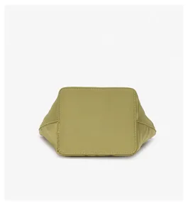 Detailed bottom view of the light green fabric hobo bucket bag, showing neat stitching.