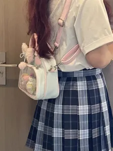 Clear PVC transparent ita bag detail view showing inner plush doll charm and pink trim.