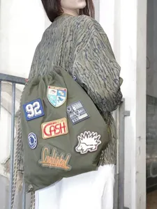 Military green drawstring backpack for women, casual travel canvas cinch bag with cute patches.