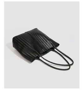 Black woven leather tote bag detail, minimalist design, elegant daily shoulder handbag.
