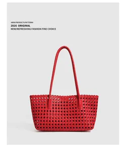 Red woven leather shoulder bag detail view, stylish minimalist fashion handbag for women.