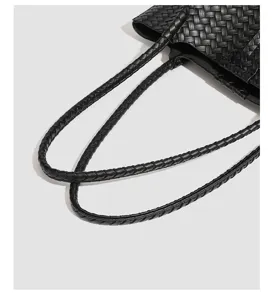 Black woven leather handle detail of a stylish casual tote bag with premium texture.