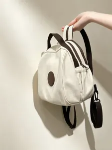 Vue détaillée du mini sac à dos en toile avec sangles marron et patch rond élégant.