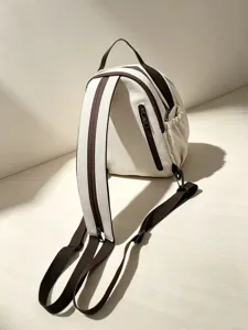 Détail rapproché du mini sac à dos en toile avec bretelles marron contrastées et poche.