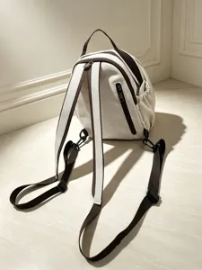 Détail de sac à dos en toile avec bretelles réglables, poche latérale et finitions.