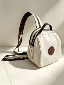 Gros plan sur les détails du mini sac à dos en toile, crème et lanières marron foncé.