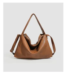 Detail view of brown soft leather shoulder bag, minimalist large capacity tote design.