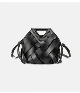 Detail view of black woven leather handbag featuring a unique rigid triangular top handle.