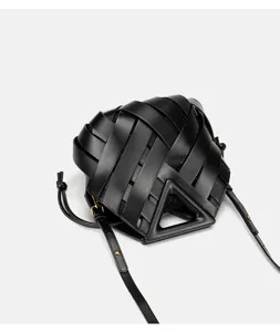Detailed view of black woven leather handbag featuring unique triangular handle and chic design.