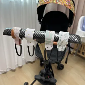 Vista detallada de ganchos para carrito de bebé de cuero PU con mosquetones para bolsos.