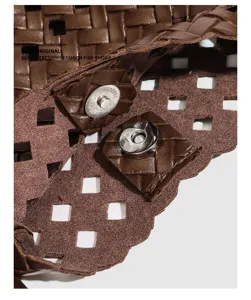 Brown woven leather crossbody bag detail view with chic hollow out design and metal snap closure.