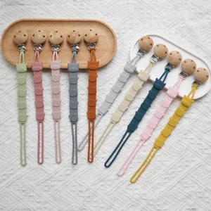 Silicone pacifier clip baby soothing chain with wooden clip and cute cartoon cow design.