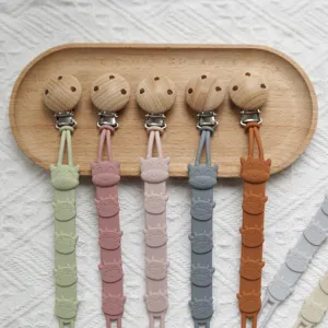 Silicone pacifier clip with cute cartoon cow design, wooden bead and metal clip for baby safety.