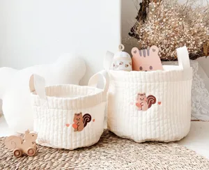 Detail view of quilted fabric storage basket with cute bear embroidery and convenient handles.
