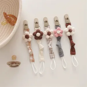 Handmade knitted flower baby pacifier clip detail, cute fabric teething strap holder.