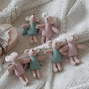 Close up detail of cute 10cm miniature mouse plush dolls with angel wings and dresses on knit.