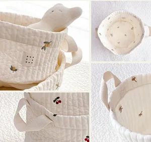 Detailed view of quilted cotton storage basket with cute embroidery and sturdy handles.