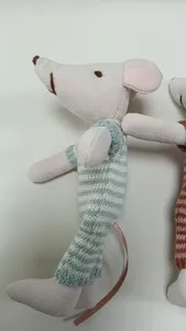 Close-up detail of miniature cotton linen mouse doll with striped knitted outfit.