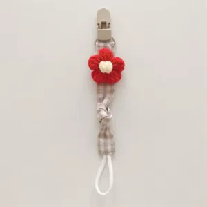 Handcrafted knitted flower baby pacifier clip with cute plaid strap and secure plastic clasp.