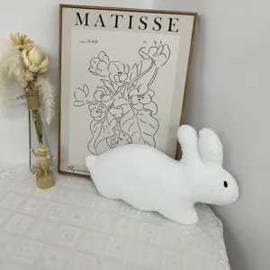 Detailed view of the cute white plush rabbit toy in a cozy home decor scene with dried flowers.