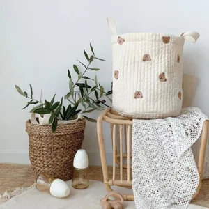 Detailed view of the cute quilted storage basket with lovely bear embroidery and dual handles.