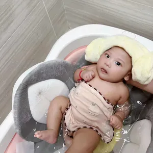 Primo piano che mostra il tappetino da bagno per neonati a petalo che supporta un bimbo felice.