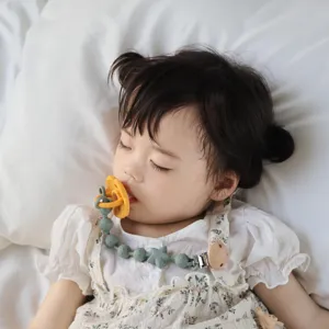 Detailansicht Schnullerclip aus Silikon, weiche Perlen und Holzclip für Babys Alltag.