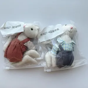 Detailed view of cute lop-eared bunny plush dolls in plaid shirts and cute linen overalls.