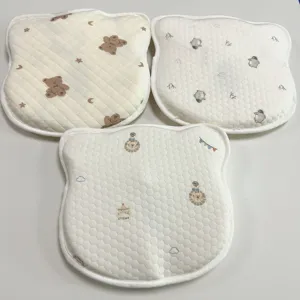 Detailopname van drie schattige babykussens met beren-, pinguïn- en circusprint, zachte stof.