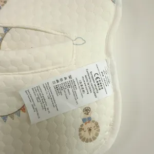 Gedetailleerd overzicht van het wasetiket van het babykussen met materiaalinformatie en wasadvies.