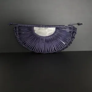 Detailed view of the chic handmade woven semi-circular crescent handbag with inner pocket.